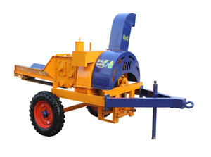 Small farm field showing a multicrop thresher machine in operation with golden wheat grains separating from stalks during harvest season